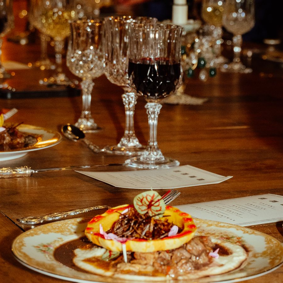 Verres de cristal et assiette dressée sur la table du manoir