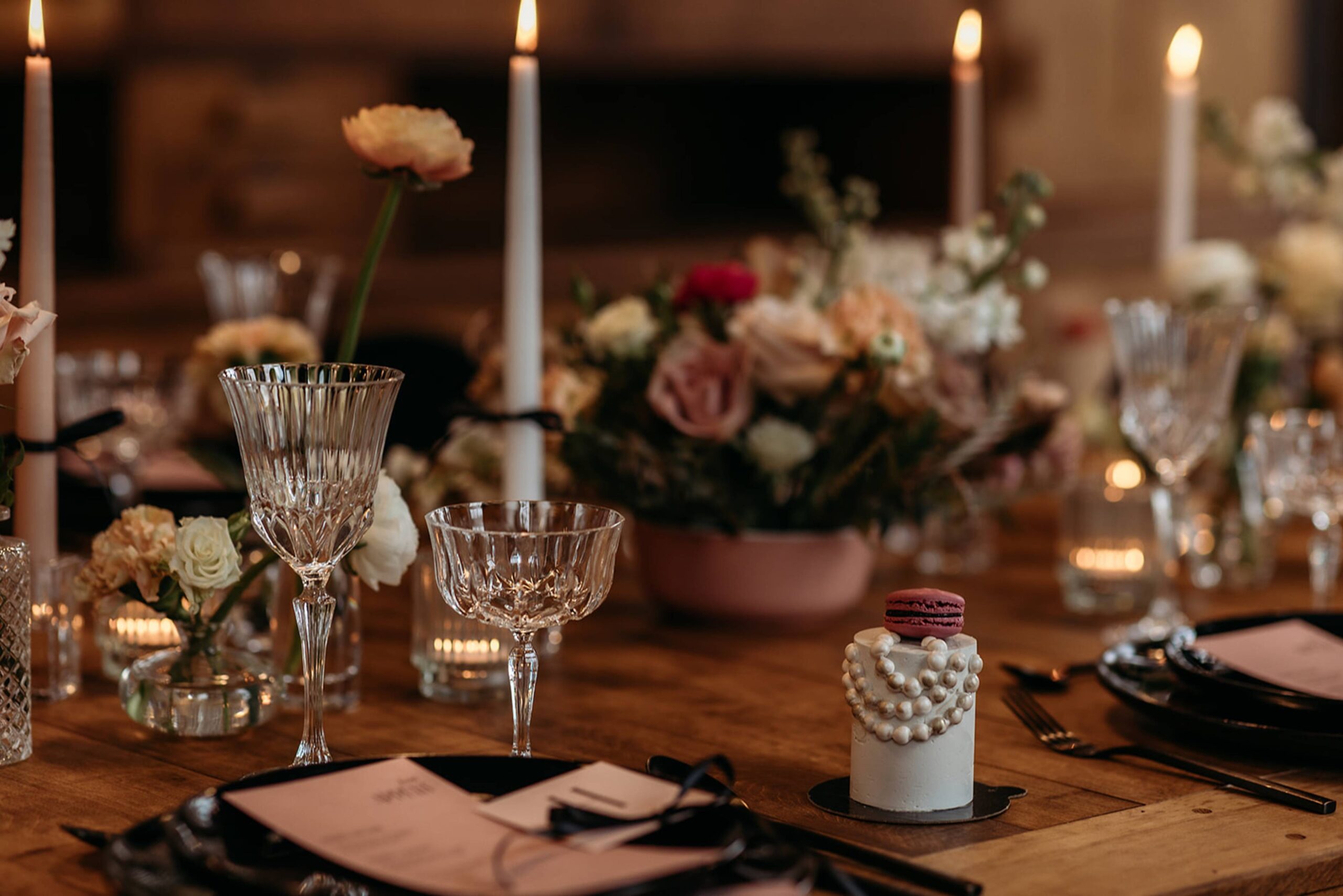 Crystal glasses, flowers and candles on a wooden table at Manoir Blackswan