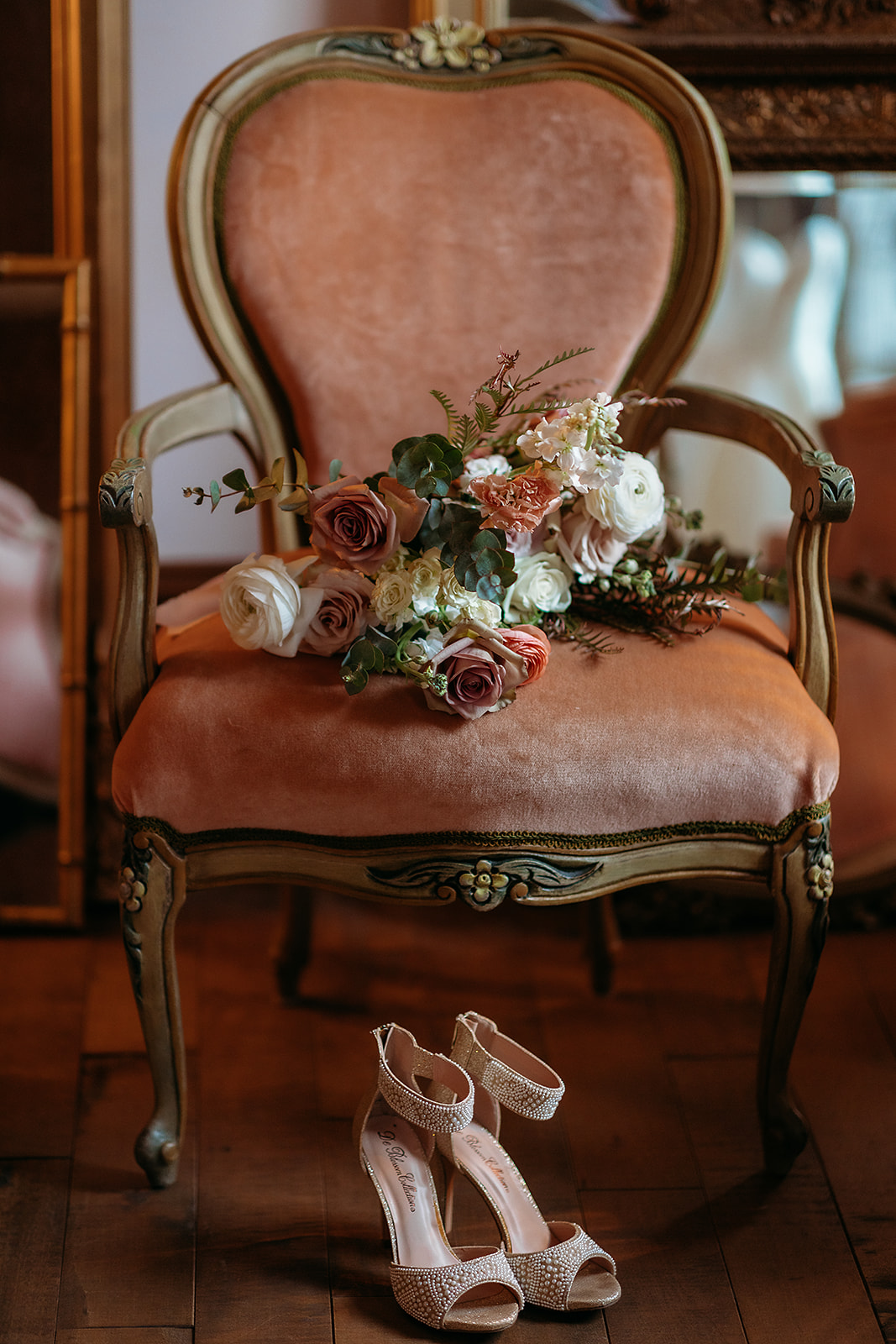 Un bouquet posé sur un fauteuil de velours et des souliers de mariée, au Manoir Blackswan