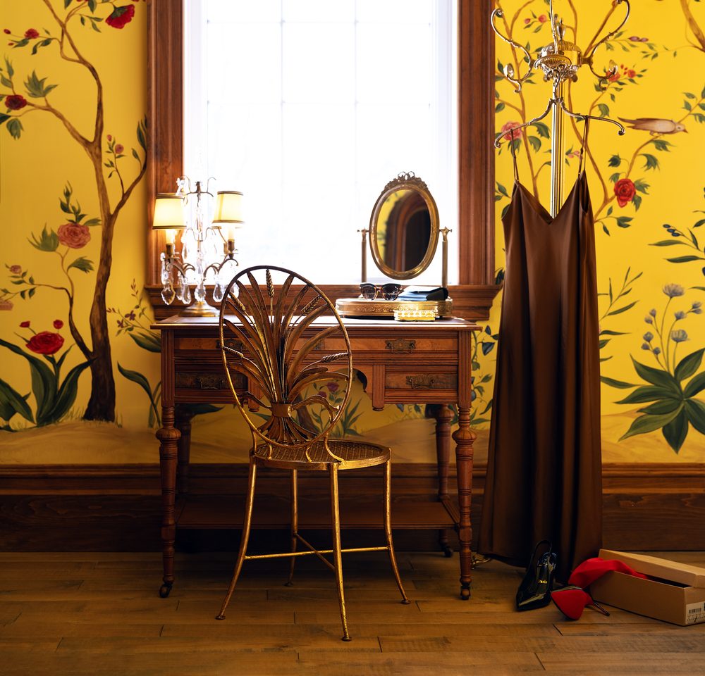 La coiffeuse de la chambre Huáng, chaise dorée et miroir ovale devant la fenêtre
