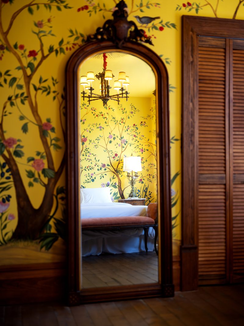 Le grand miroir de la chambre Huáng, où se reflètent le lustre et le lit