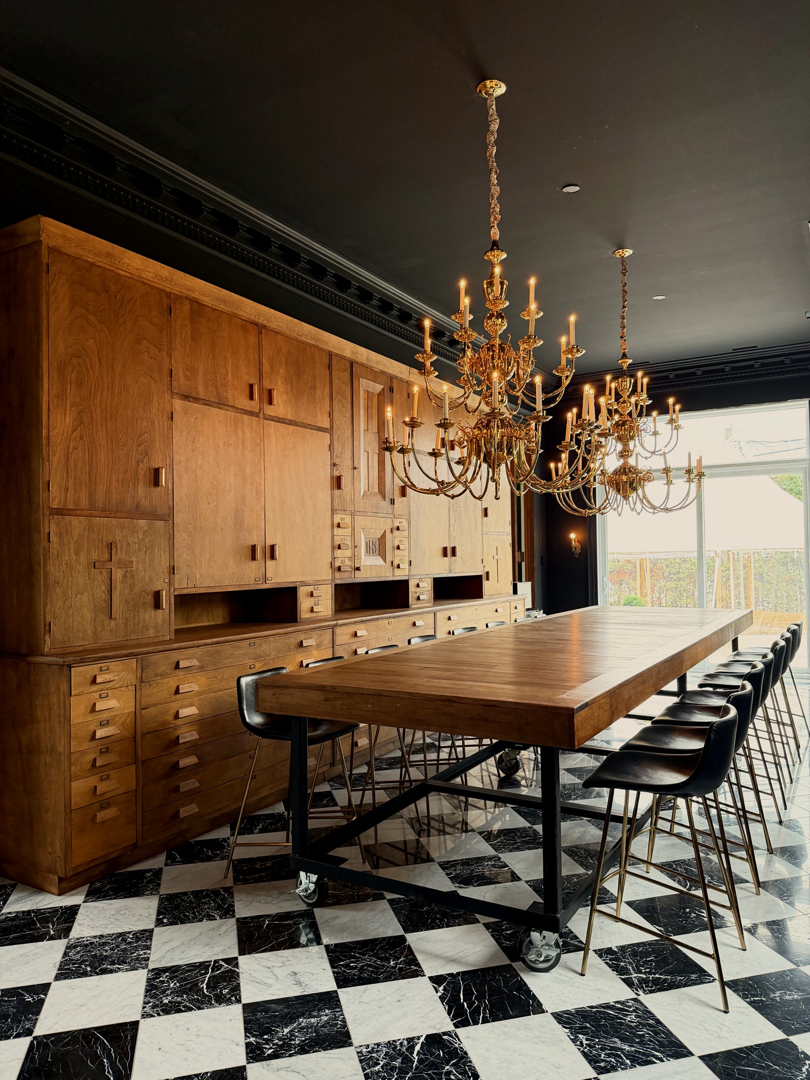L'espace commun du Manoir Blackswan, ses armoires de bois, sa longue table et ses lustres de laiton
