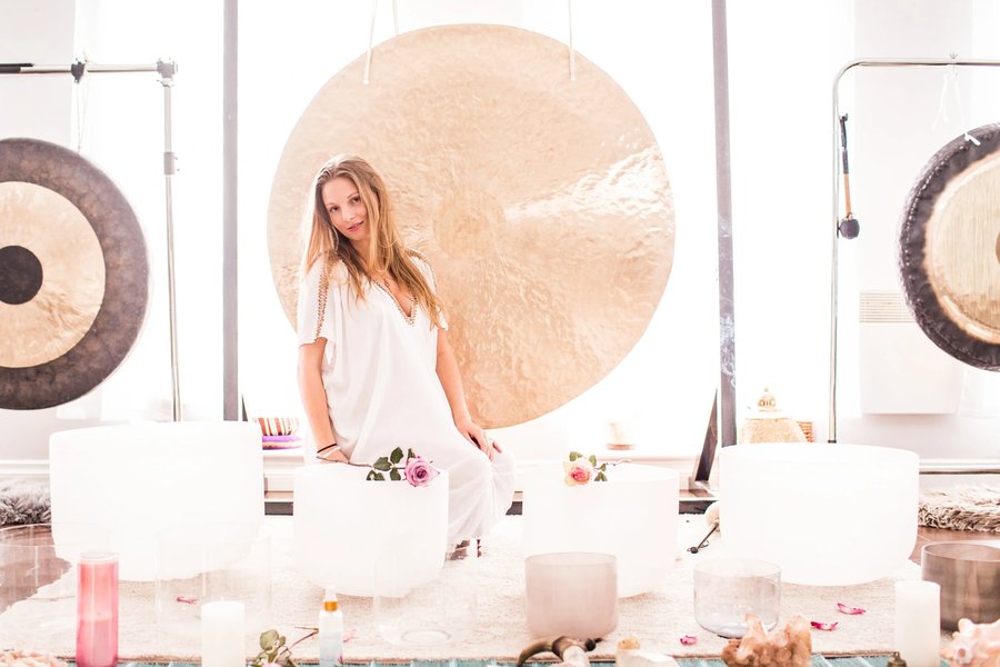 Sarah Surrenders seated among her crystal bowls and gongs