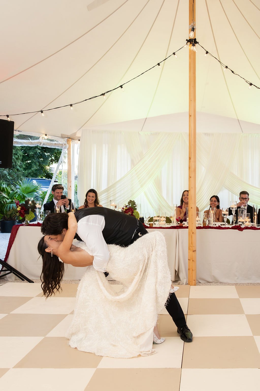Les mariés s'embrassent sur la piste de danse, sous la tente Sperry