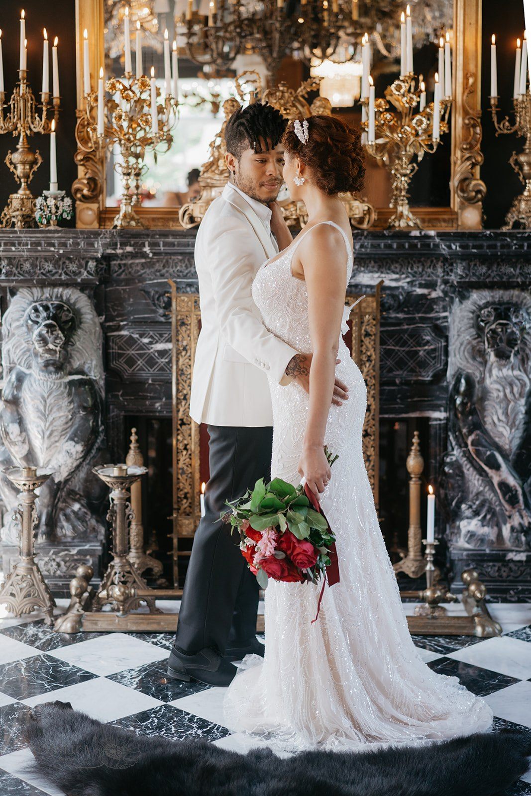 Couple de mariés devant le foyer sculpté du grand salon
