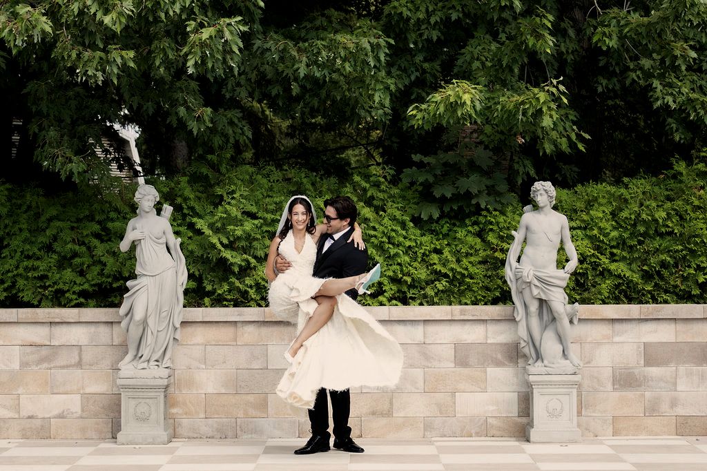 Couple de mariés sur la terrasse damier, entre les statues du jardin